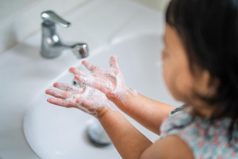 a young girl washing her hands